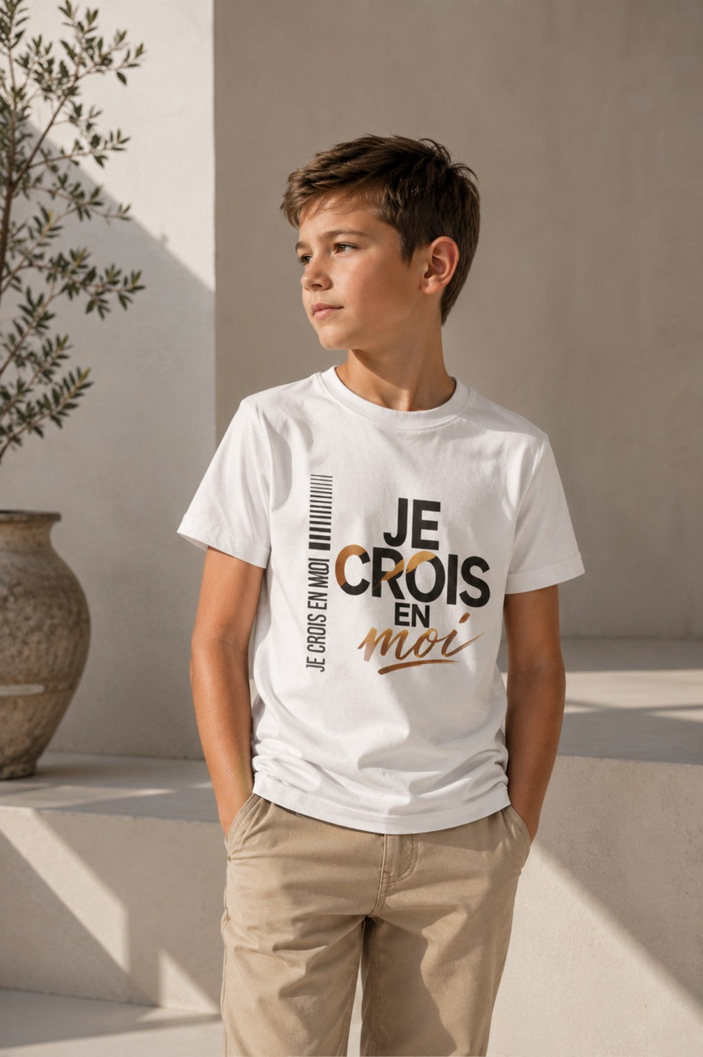 Enfant assis portant un t-shirt inspirant « Je crois en moi ».